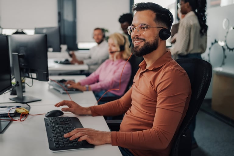 Agentes de centro de contacto con audífonos trabajando en su estación dentro de una oficina
