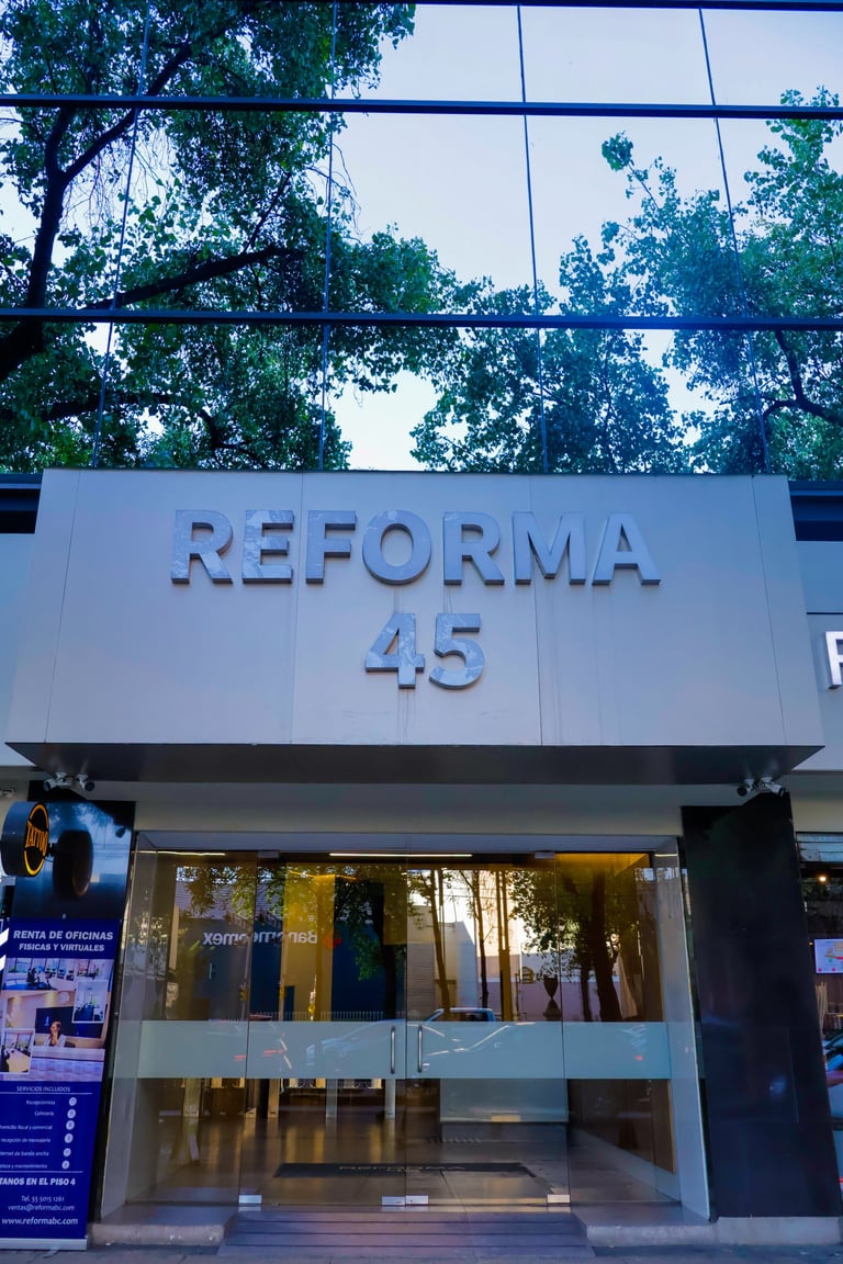 Modern storefront with REFORMA 45 signage on white facade, glass entrance, and trees visible above