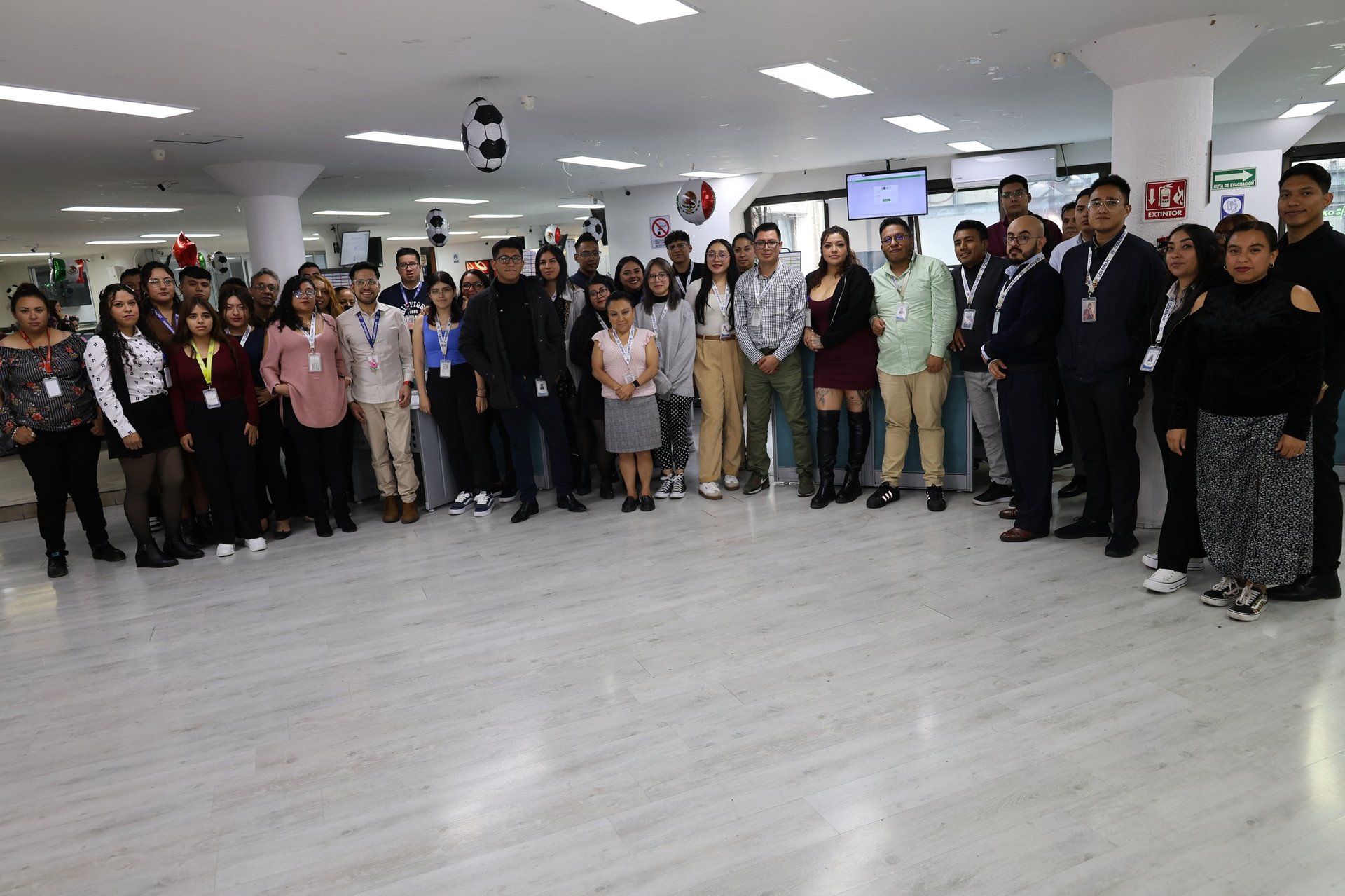 Large group of people standing together in a modern office or conference room for a team photo